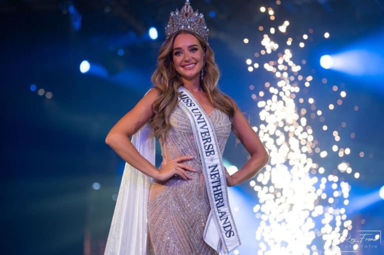 The winner of the Miss contest presents herself on stage with sash and crown.