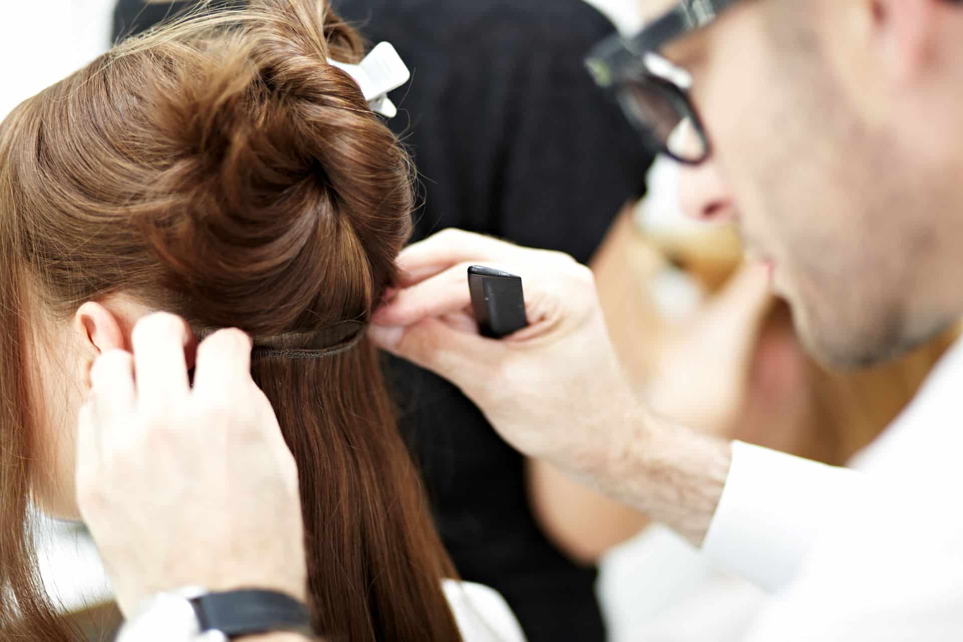 Hairdresser fixes the Hairdreams real hair braid to the client's own hair.